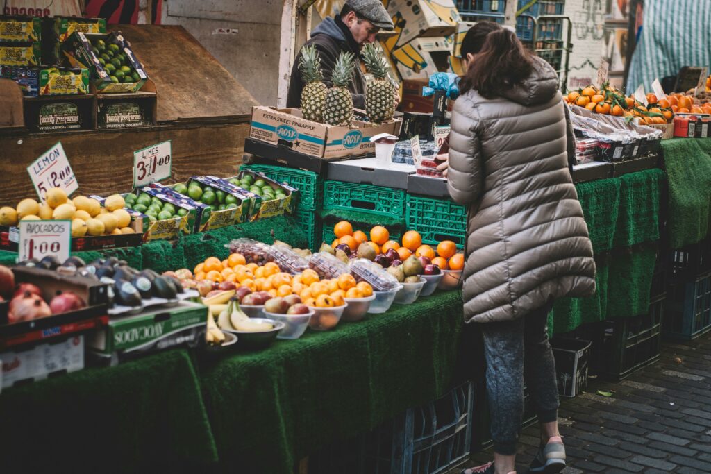 a woman standing at a fruit stand