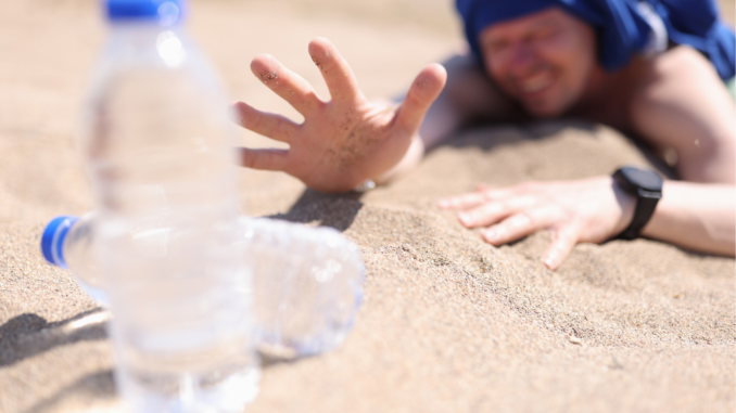 a very thirsty woman about o grab a bottle of water