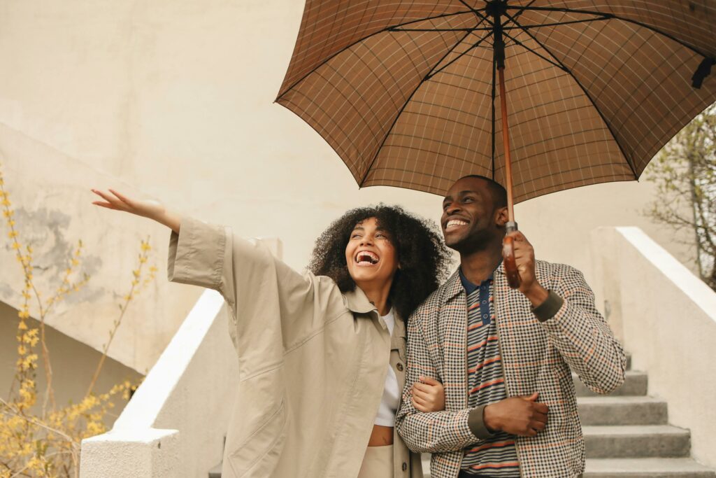 husband and wife standing under an umbrella