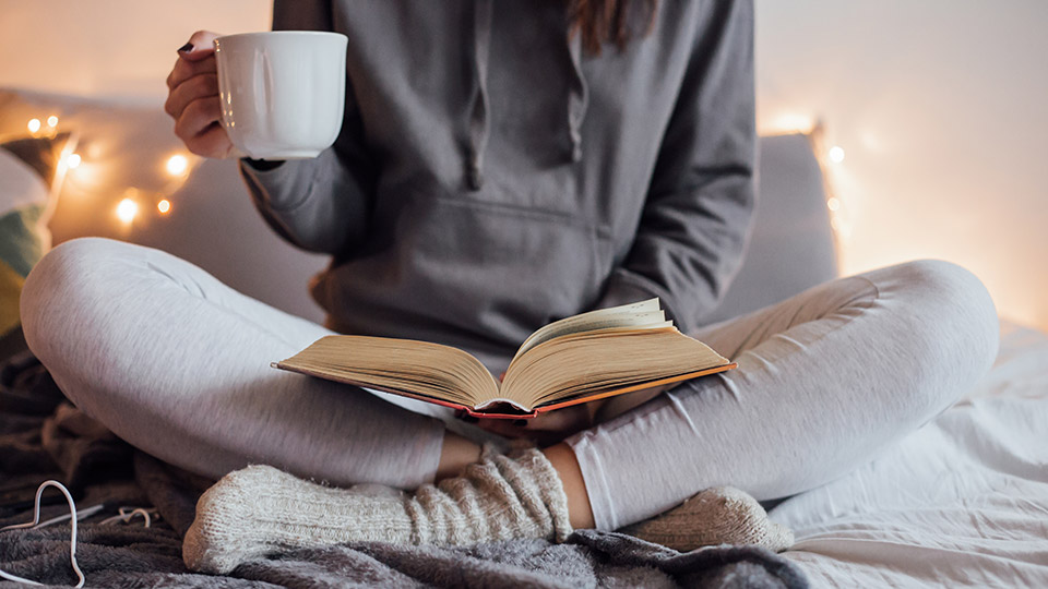 A woman reading book on bed