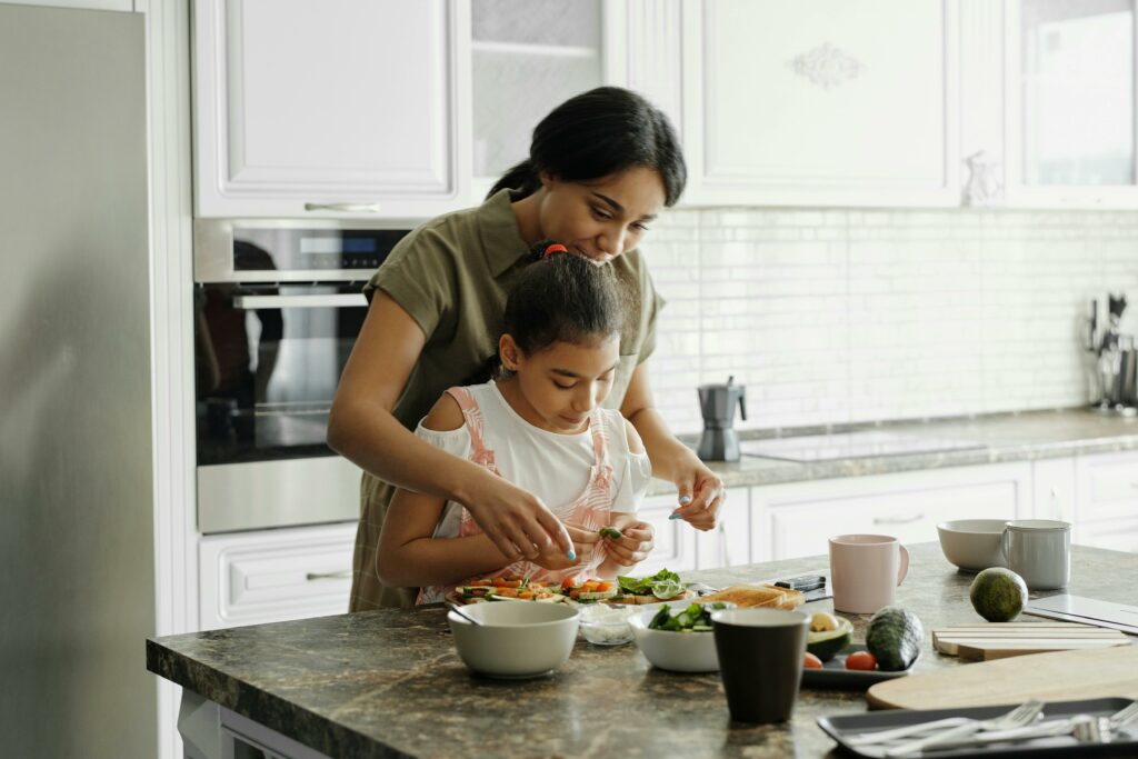 a woman teaching her daughter  how to cook