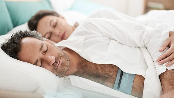 Husband and wife sleeping together while the wife hold her husband arm