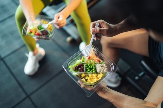 two people eating fruits with forks