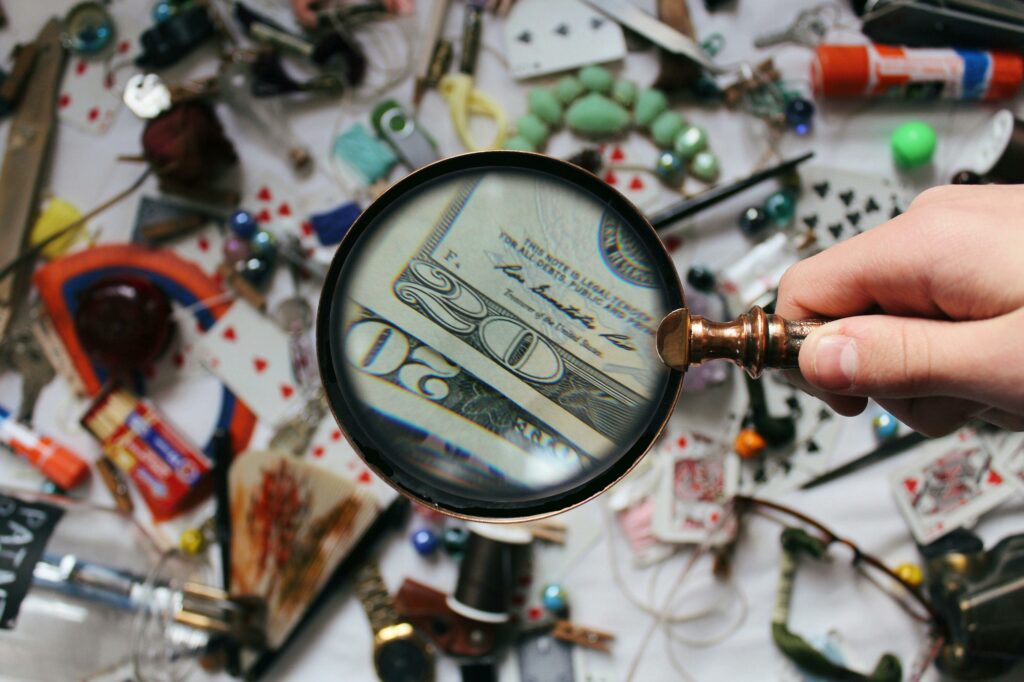 someone holding a magnifier to check money