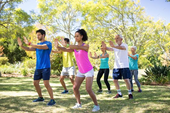 Group of people exercising in the park on a sunny day