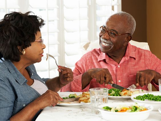 husband and wife eating and smiling