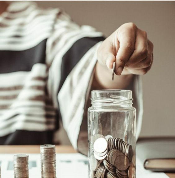 a woman saving coins is a piggy bank