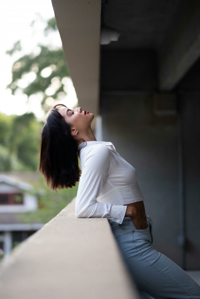 Woman in White Shirt Leaning on Wall