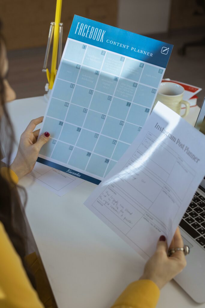 a hand holding a paper with social media content planner writing in the paper