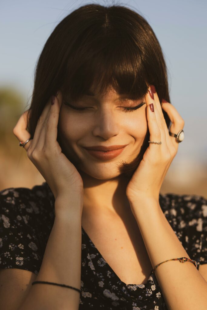 Selective Focus Photography of Smiling Woman With Hands on Face