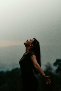 Woman with Arms Apart Looking Up in the Sky