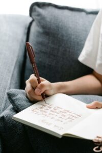 A Person Writing in a Notebook