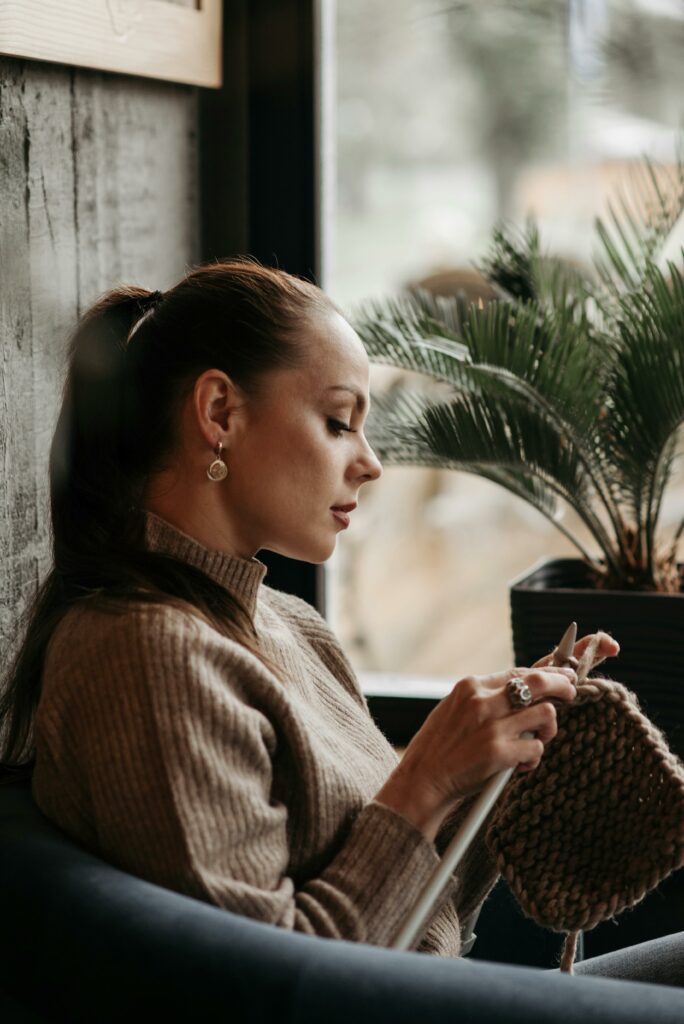 Woman Holding a Crochet and Knitting Needles