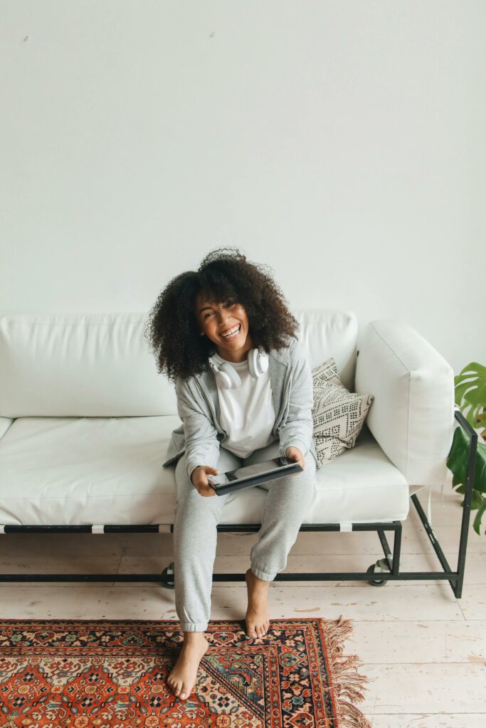 Woman Laughing While Sitting on Sofa