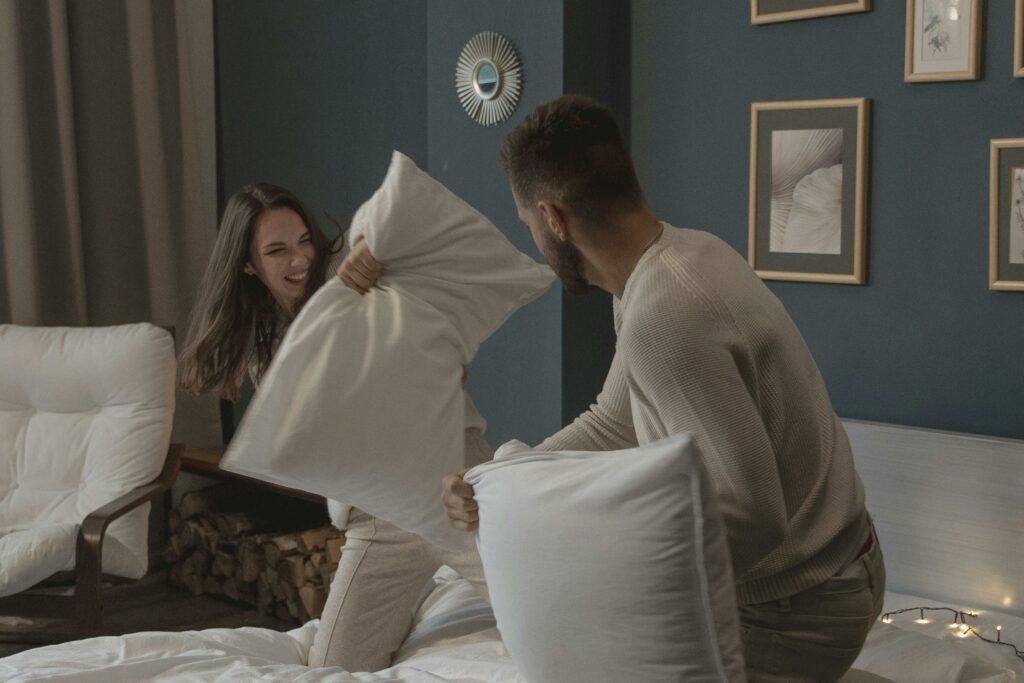 A Couple Having Fun Playing Pillow Fight