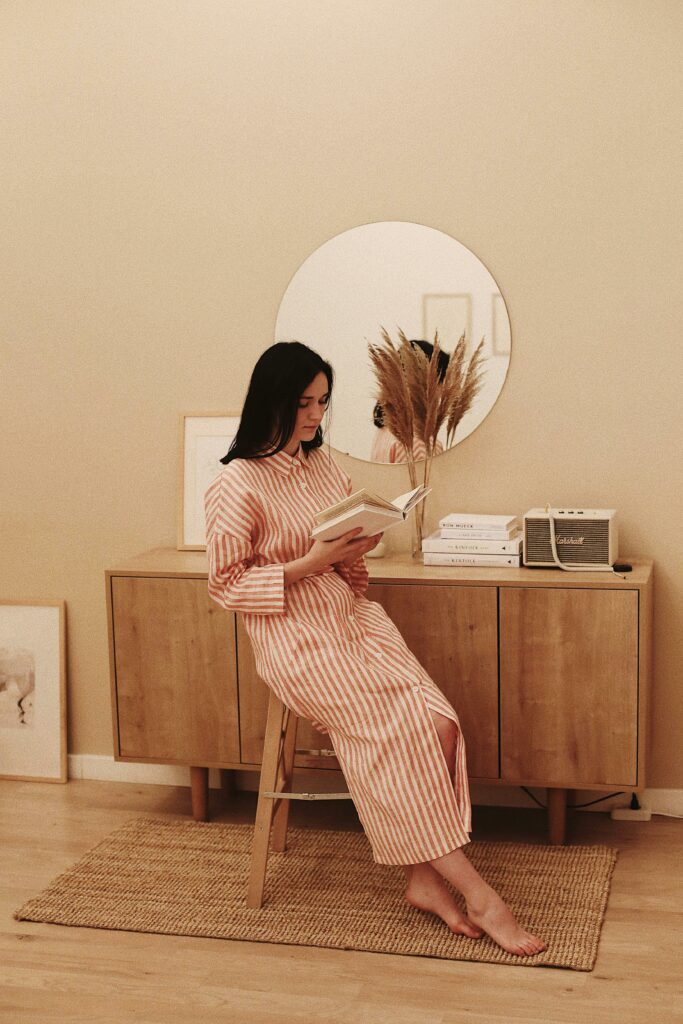 Woman in Stripe Dress Sitting on Brown Wooden Chair